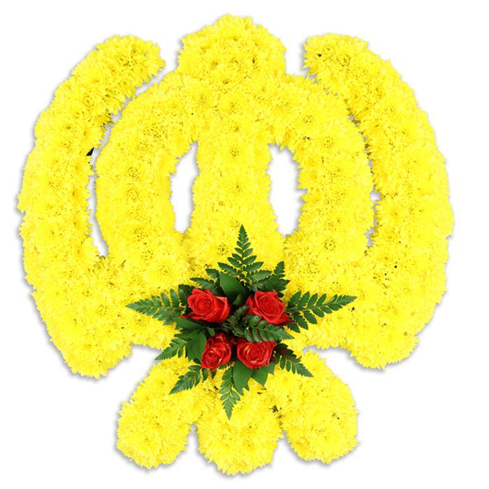 An expert florist's tribute to Sikh symbolism, carefully photographed on a spare white surface so every floral stitch of the Khanda is visible. The emblem's circular chakram, the prominent central double-edged khanda and the two inward-sweeping kirpans are all sculpted from a dense, sun-bright field of small yellow chrysanthemums; each bloom is placed to maintain the sign's curves and to build a slightly raised, cushion-like texture. The chrysanthemums' petals read soft and silky under soft studio light, their yellow hue warm without being garish. At the emblem's heart sits a small, intentional cluster of five deep red roses-velvet-petaled and tightly formed-nestled into an embrace of dark green fern fronds that cut a cool, structured outline against the yellow. That concentrated pop of crimson becomes the visual and emotional centre, conveying deep respect amid the celebratory yellow. The white backdrop and the faint shadow beneath the piece reinforce that this is a standalone tribute, suitable for ceremonial display, funerals or community commemorations. As a florist who works across Stanmore, from the Broadway to the green spaces around Bentley Priory, I assemble these with an eye toward both durability and dignity; they travel well and can be arranged for local delivery to services at nearby venues. The arrangement balances symbolism, colour and texture with sensitivity, reflecting the reverence of the occasion and the hands-on craft behind every placement of bloom.