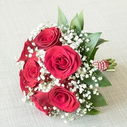 Imagined by the skilled hands at Flowers Stanmore, this exquisite bouquet harmonizes the classic allure of red roses with the softness of delicate white baby's breath, creating a vision of love that feels right at home in the Stanmore area. The deep crimson rose petals, flawlessly unfurled in tight spirals, radiate warmth and romantic energy-evoking walks through Stanmore Country Park or evenings spent on The Broadway. Curling gracefully among the bold blooms, countless miniature sprays of Gypsophila weave a gentle cloudlike contrast, infusing the bouquet with a sense of purity, innocence, and dreamlike wonder. Shining emerald-green foliage peeks from between the flowers, their privet or salal leaves gleaming under soft natural light, mirroring the peace found in lush local gardens. At the stems' base, a distinctive red and white striped ribbon is wrapped tightly, enhanced by the twirl of gleaming pearls-an artisanal detail typical of Stanmore's bespoke floral arrangements. Set upon a neutral, creamy fabric surface, the composition comes alive-a vibrant yet elegant symbol of love and celebration, perfect for bridesmaids walking down the aisle at St. John's Church or for marking timeless occasions with someone cherished. The bouquet's visual poetry and gentle fragrance carry the warmth and care of Stanmore's close-knit community, available for same-day delivery throughout the area.