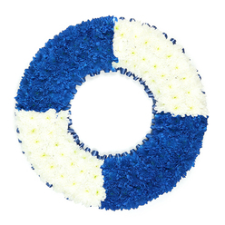 In this image, a beautifully constructed circular wreath is designed to mirror the shape and colouring of a traditional maritime life ring, set against a pure white background that enhances every curve and petal. The wreath is entirely covered with compact clusters of small, daisy-like flowers, arranged so closely that they form a continuous, textured surface with only the faintest dips and rises where the blooms interlock. The circle is divided into four balanced quadrants, alternating between intense royal blue and clean white in a steady rhythm. The blue sections, placed at the upper left and lower right, create a bold visual anchor, their rich pigment reminiscent of deep ocean water or even the clear blue of a winter sky over Stanmore Common. The white quadrants at the upper right and lower left introduce lightness and serenity, evoking purity, remembrance, and the peace wished for a loved one at their final rest. Around the inner edge of the wreath, a slim band of dark blue ribbon is gently gathered into small, regular folds, forming a neat ruffled border that outlines the central opening and subtly underlines the nautical theme. Nothing about the arrangement is fussy; the design is clean, symmetrical, and deeply symbolic. This lifebuoy-style floral tribute feels especially appropriate for honouring someone who served at sea, loved sailing or coastal life, or was simply known as a steady support in difficult times. At a funeral or crematorium service in Stanmore, it would make a heartfelt focal piece, expressing themes of rescue, guidance, and a safe passage onward with quiet elegance.