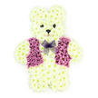 In this photograph, a three-dimensional teddy bear made entirely from fresh flowers is displayed against a plain white background, creating a peaceful, focused composition. The bear's entire form-head, ears, body, arms, and legs-is densely covered in small creamy white chrysanthemums, each bloom pressed closely against the next to recreate the soft, plush look of teddy bear fur. The shape is rounded and comforting, with the bear shown in a seated position, little paws resting forward as if in a quiet embrace. The facial details are minimal but expressive: two dark flower centres become round, button-like eyes, and another dark bloom creates the nose, with petals arranged to imply a gentle, almost wistful smile. Across the bear's chest runs a distinctive waistcoat formed from vivid purple and lilac flowers, carefully grouped to give the impression of fabric and featuring defined lapels that add character and a touch of formality. At the neck, a small bow made of lilac mesh sits neatly, its light, translucent texture catching the light and softening the overall design. The colour palette-creamy whites with cool purples-evokes serenity, making this tribute particularly suitable for children's funerals or memorial services. One can imagine it resting upon a stand at a Stanmore church or crematorium, perhaps near the leafy surrounds of Canons Park or along the quieter residential streets off Marsh Lane. Crafted by a skilled florist serving the Stanmore area, this floral teddy bear offers more than decoration: it is a gentle, symbolic companion, designed to bring a sense of innocence, comfort, and enduring affection to a time of loss.